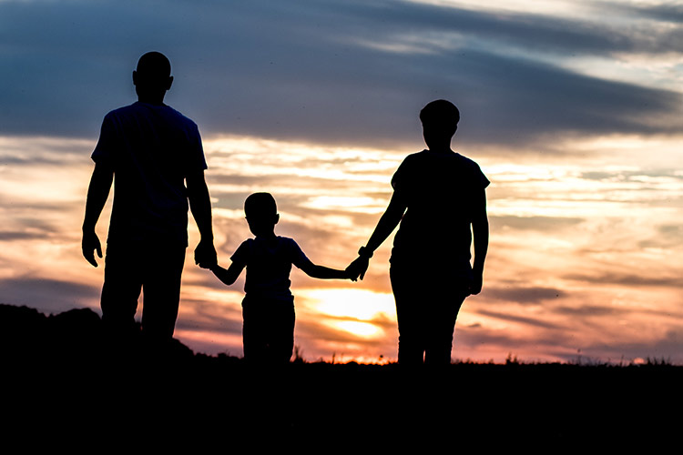 Die Familie läuft für Familienfotos Richtung Sonnenuntergang.